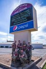 Members of the 135th Army Band's "Fire for Effect" pose for a picture of the sign advertising their performance at the Venue, prior to the show.