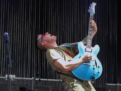 Roger Kirchner plays guitar during a performance with the 135th Army Band's rock band "Fire for Effect."