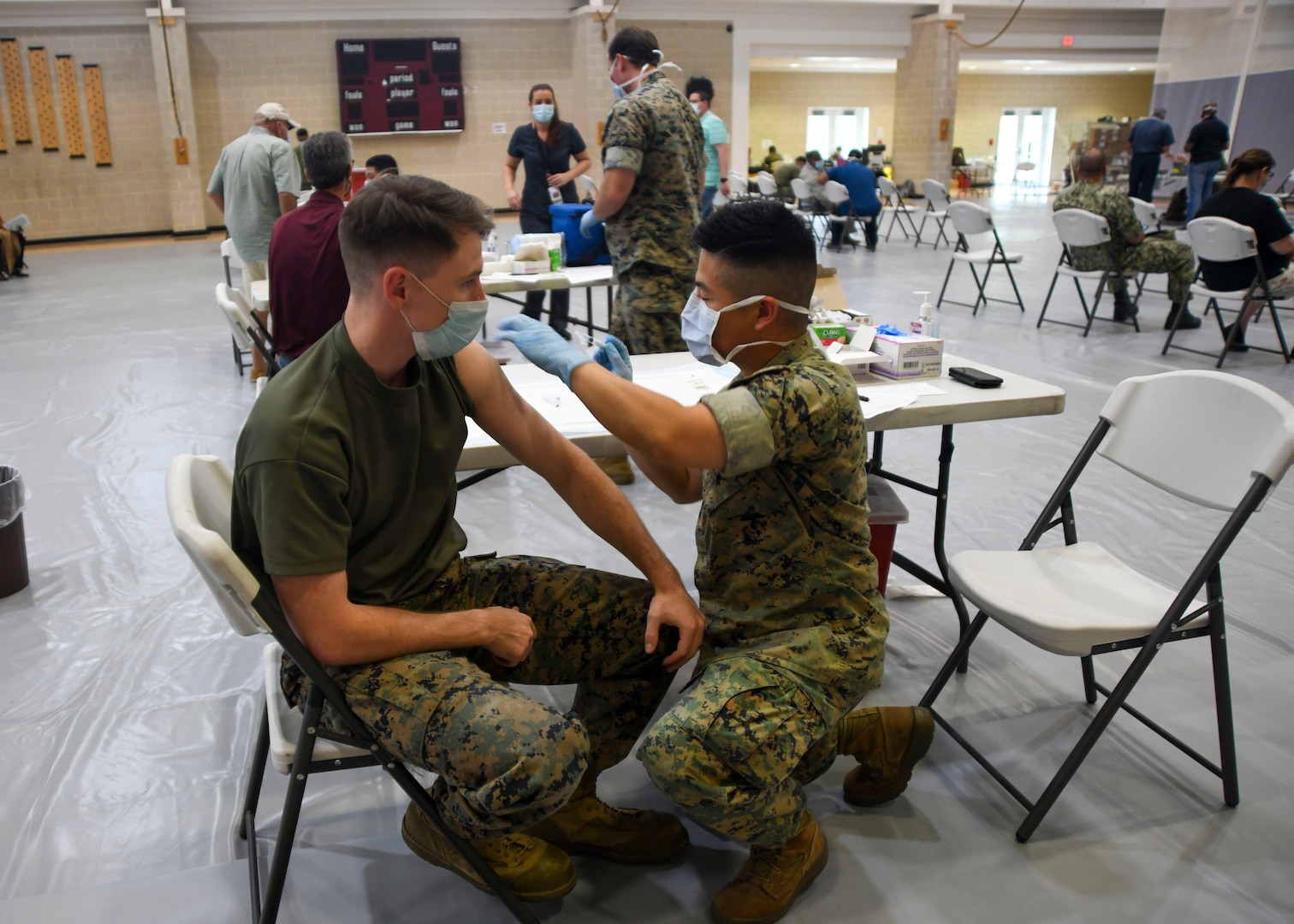 Service member administers vaccine
