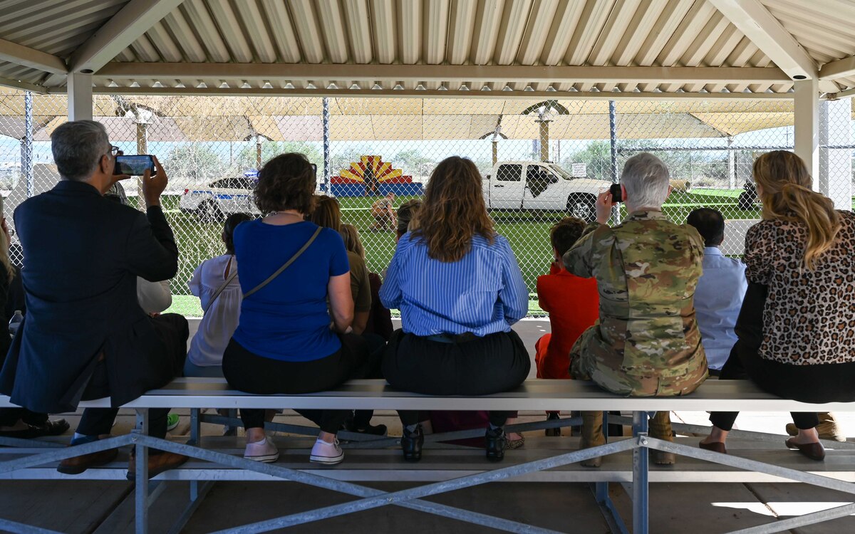 A photo of people watching a military working dog demonstration.