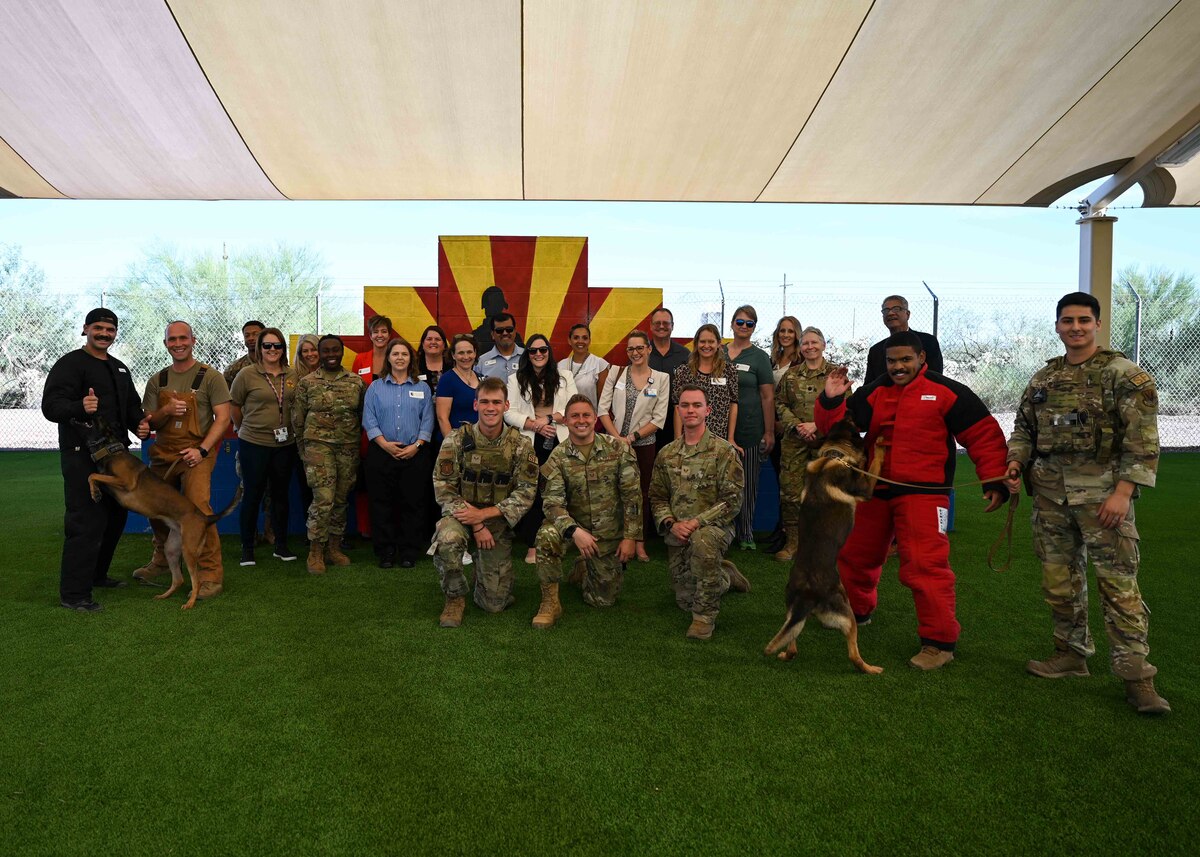 A group photo of medical providers, people in uniform and military working dogs.