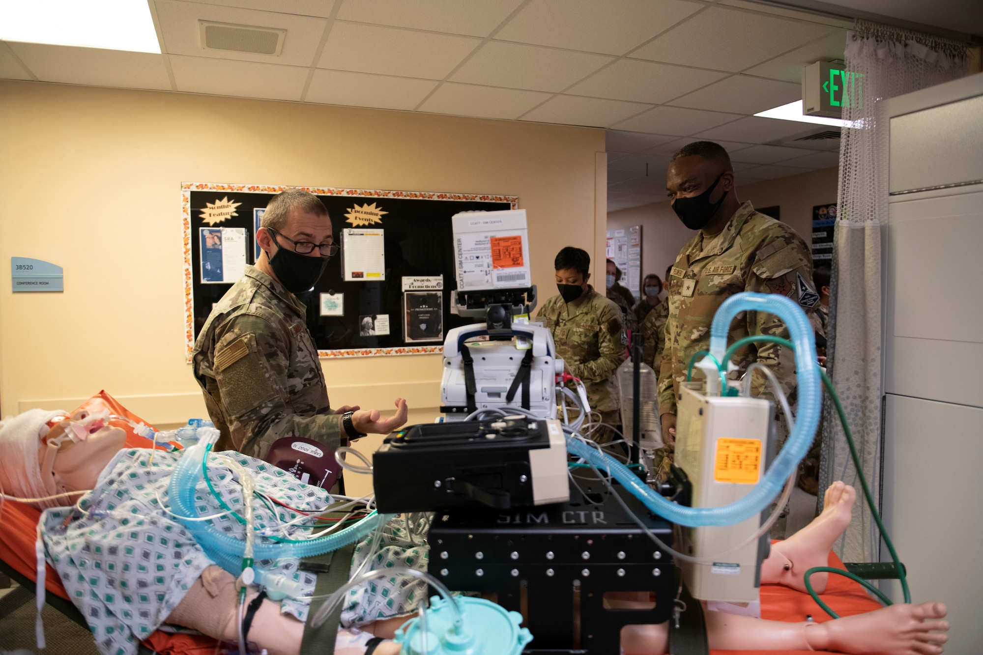 With a simulated dummy patient with medical equipment attached shown in the foreground, an Airman briefs Brig. Gen. Alfred K. Flowers, Jr., at David Grant USAF Medical Center, Travis Air Force Base, California, Oct. 12, 2022.