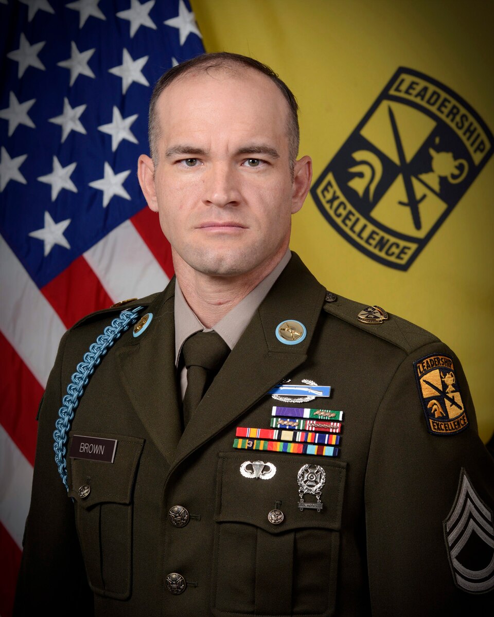 Portrait photo of soldier in front of flags.
