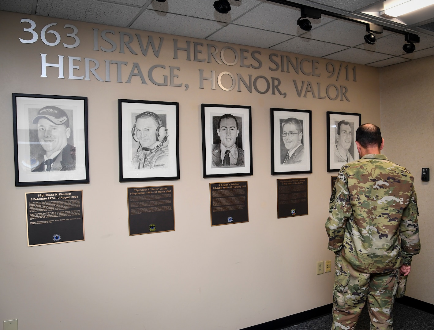 Person stands in front of a Memorial Wall and reads.