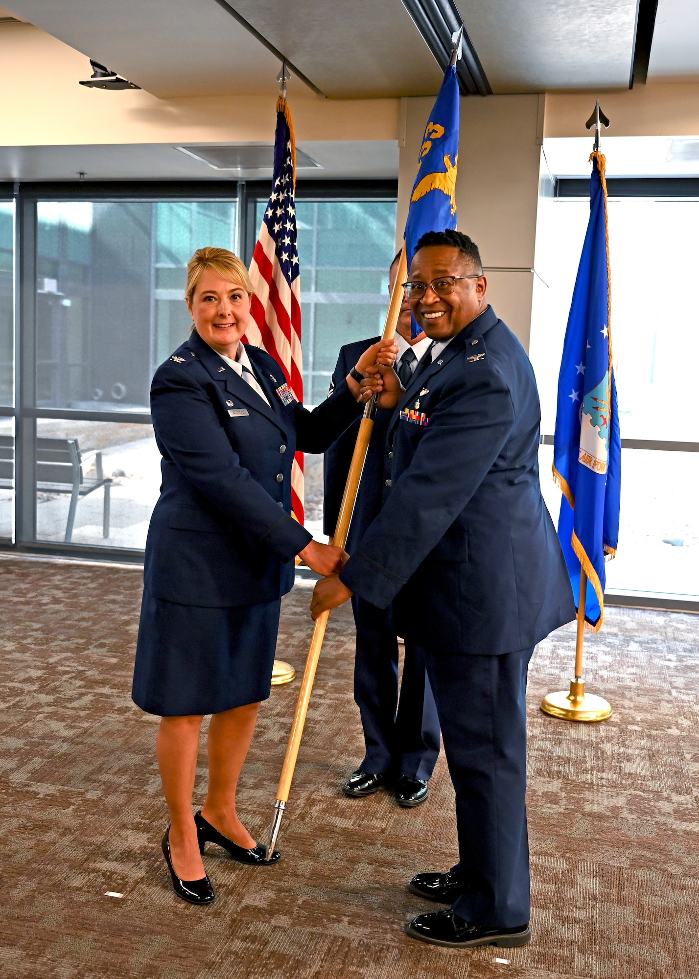 Col. Michelle Van Sickle, 433rd Medical Group commander, presents the leadership guidon to Col. Alvin Bradford, 433rd Medical Squadron commander, Oct. 16, 2022, during the 433rd MDS assumption of command ceremony at Joint Base San Antonio-Lackland, Texas. (U.S. Air Force photo by Staff Sgt. Monet Villacorte)