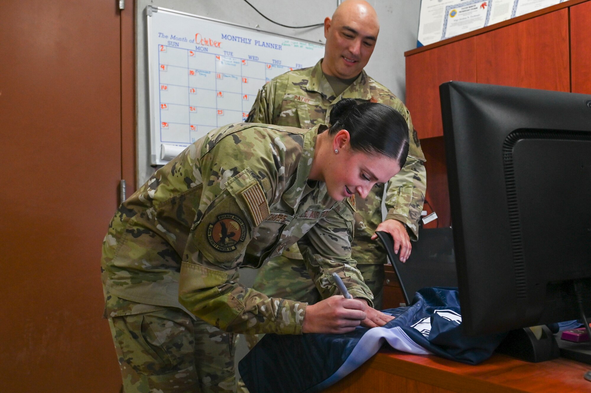 An Airman signs a jersey.