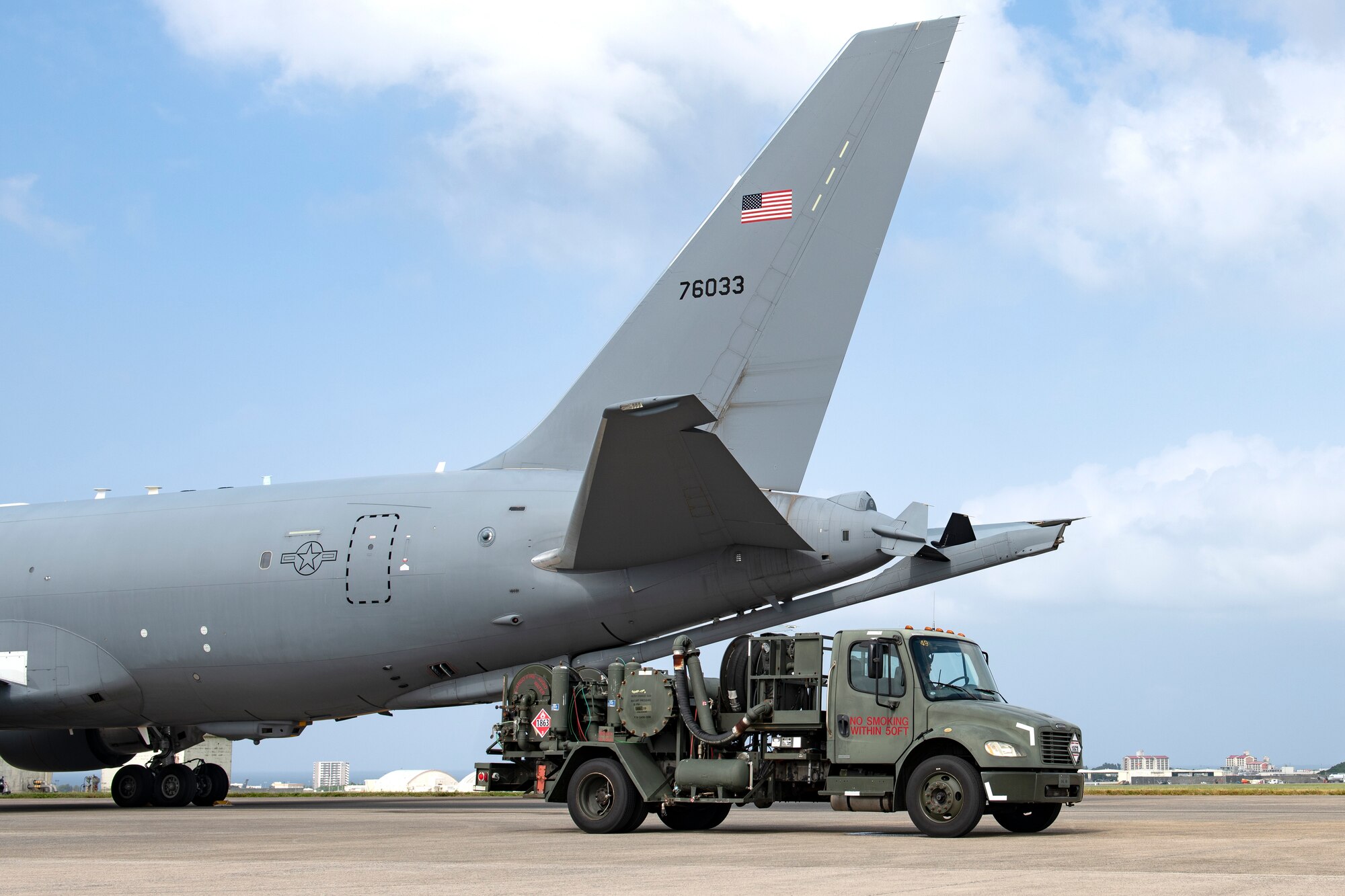 A KC-46A Pegasus from McConnell Air Force Base is parked alongside an R-12 refueling truck for hot pit refueling at Kadena Air Base, Japan, Oct. 13, 2022. Hot pit refueling is a technique used to reduce the ground time between flights as well as manpower and equipment requirements. (U.S. Air Force photo by Senior Airman Jessi Roth)