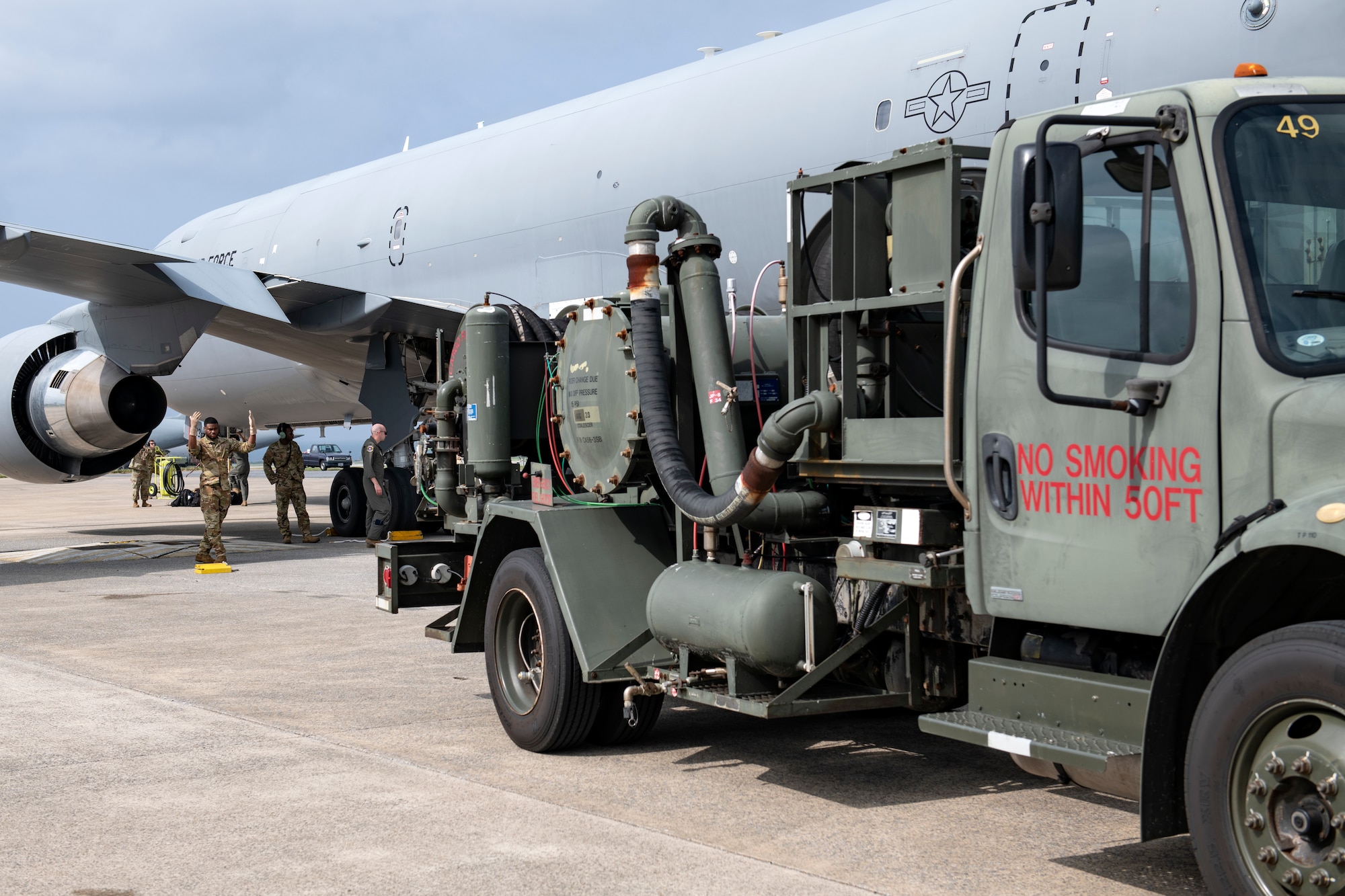 An Airman from the 22nd Air Refueling Wing marshals an R-12 refueling truck into position for hot pit refueling operations at Kadena Air Base, Japan, Oct. 13, 2022. Hot pit refueling is a technique used to reduce the ground time between flights as well as manpower and equipment requirements. (U.S. Air Force photo by Senior Airman Jessi Roth)