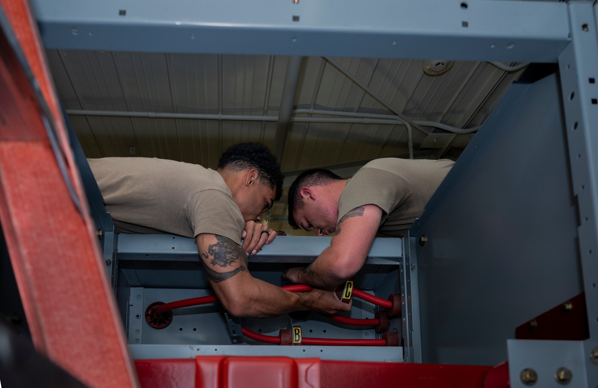 U.S. Air Force Tech. Sgt. Jonathan Steele, 51st Civil Engineer Squadron NCO in charge of electrical exterior section and Staff Sgt. Brendan Kerwin, 51st CES electrical systems journeyman removes bolts from the top of a switchgear at Osan Air Base, Republic of Korea, Oct. 10, 2022.