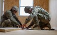 From left, Sgt. Austin Hendrix and Spc. Jaxen Jenson, both with the 461st Engineer Company, sketch out a stair support for a building at Tactical Training Base Liberty on Fort McCoy, Wis., October 19, 2022. The building will be used by U.S. Army Reserve units when they train here. (U.S. Army Reserve photo by Zach Mott, 88th Readiness Division Public Affairs Office)