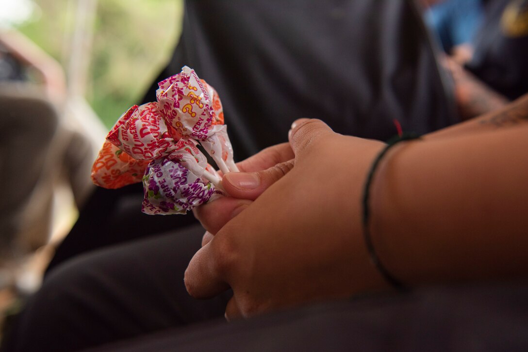 U.S. Army Sgt. Harley Miller, Defense POW/MIA Accounting Agency (DPAA) Mortuary Affairs assistant, holds a cluster of Dum Dums during a recovery mission in Lao People’s Democratic Republic, Oct. 15, 2022. Harley formed a connection with a local family by giving out candy to some of the children. DPAA’s mission is to achieve the fullest possible accounting for missing and unaccounted-for U.S. personnel to their families and the nation. (U.S. Air Force photo by Staff. Sgt. Blake Gonzales)