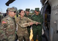 U.S. Army Sgt. 1st Class Marcia McNeill, assigned to the 2nd General Support Aviation Battalion, 3rd Combat Aviation Brigade, 3rd Infantry Division, from Hunter Army Airfield, Ga., explains the medical evacuation capabilities of an HH-60M Blackhawk helicopter to Joint Task Force Civil Support commanding general, U.S. Army Maj. Gen. Jeffrey Van and Mexican army General De Brigada (Maj. Gen.) Roberto Claudio del Rosal Ibarra, the 8th Military Zone commander, during exercise Fuerzas Amigas 2022 at Campo Militar Reynosa, Mexico, Oct. 19, 2022.