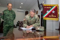 Joint Task Force Civil Support commanding general, U.S. Army Maj. Gen. Jeffrey Van signs a guest logbook as Mexican army General De Brigada (Maj. Gen.) Roberto Claudio del Rosal Ibarra, the 8th Military Zone commander, looks on at Campo Militar Reynosa, Mexico, during exercise Fuerzas Amigas 2022 Oct. 19, 2022.