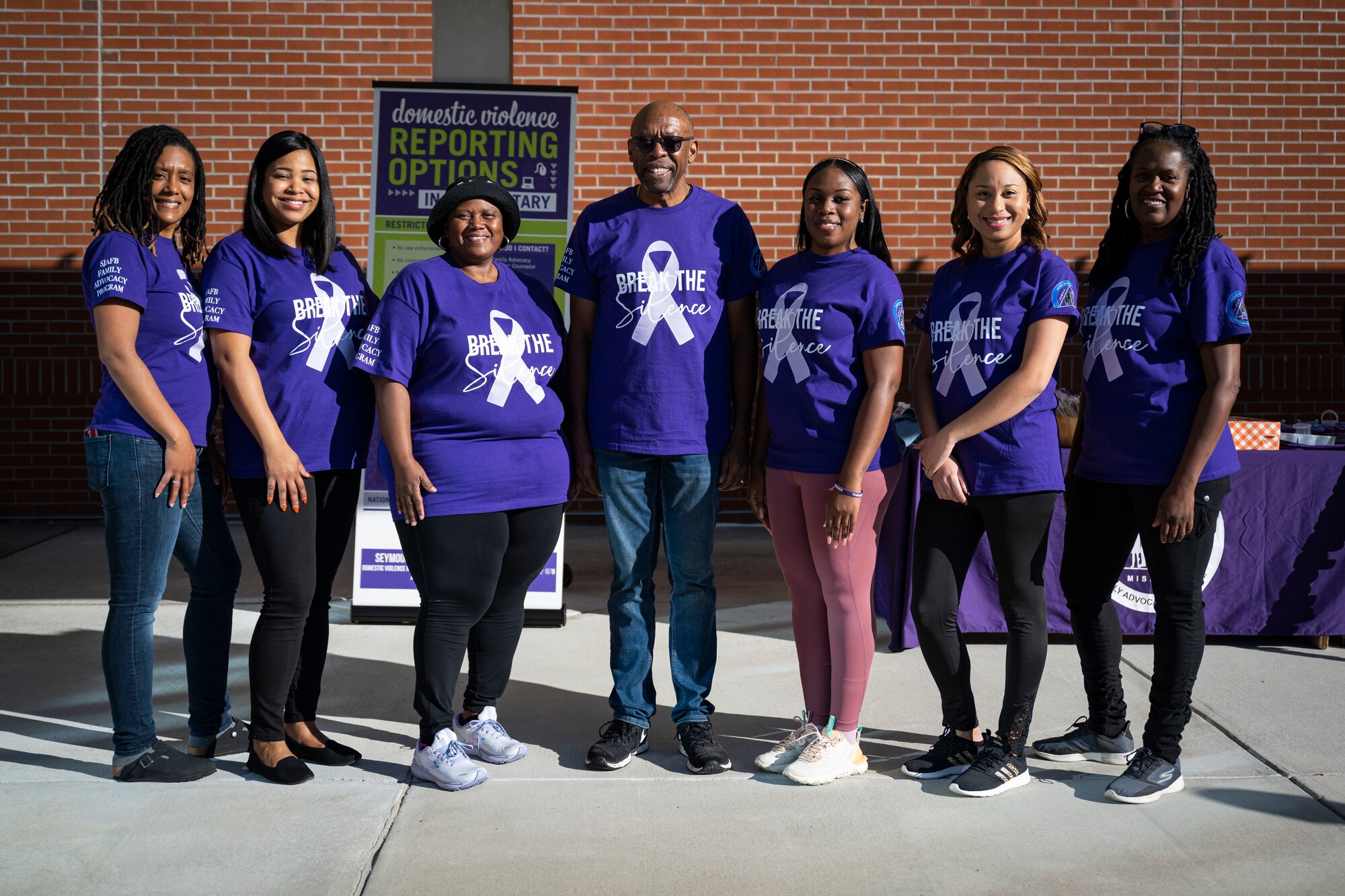 Members of the 4th Operational Medical Readiness Squadron Family Advocacy Program, pose for a photo during a domestic violence awareness event at Seymour Johnson Air Force Base, North Carolina, Oct. 20, 2022. The Family Advocacy Program offers prevention, education and outreach services against child and spouse abuse.