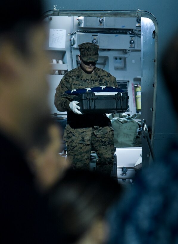 U.S. Marine Corps Sgt. Ross Neeley, assigned to Defense POW/MIA Accounting Agency (DPAA), carries remains of a possible U.S. service member off of a U.S. Air Force C-17 during an honorable carry ceremony on Joint Base Pearl Harbor-Hickam, Oct. 15, 2022. The remains returned from the Independent State of Papua New Guinea as part of the conclusion of a recovery mission hosted in their country. DPAA’s mission is to achieve the fullest possible accounting for missing and unaccounted-for U.S. personnel to their families and our nation. (U.S. Marine Corps photo by Sgt. Morgan L. R. Burgess)