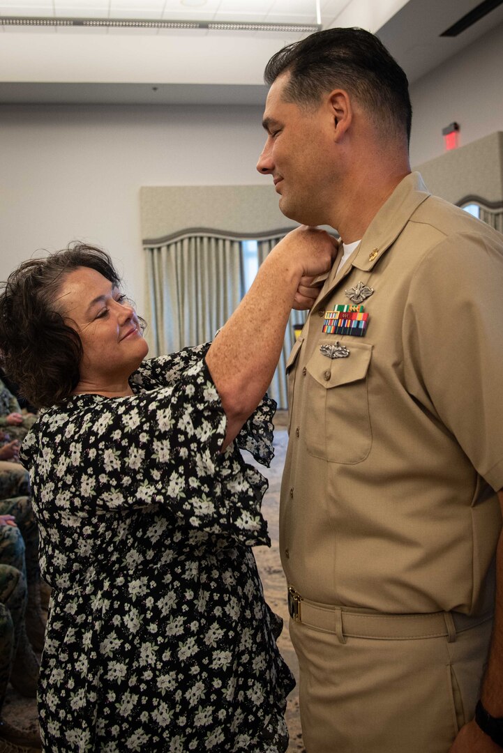 Chief Petty Officer Peter Austin receives his new rank from his wife during his promotion ceremony.  Austin and four other sailors advanced to the rank of “Chief” during the ceremony held Friday, October 21, 2022, aboard Marine Corps Air Station Cherry Point.