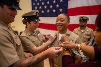 NAVAL STATION NORFOLK (Oct. 21, 2022) Family members and mentors pin Chief Hospital Corpsman Monique Brown’s anchors during the Naval Surface Force Atlantic chief petty officer pinning ceremony onboard Naval Station Norfolk, Oct. 21. Nine Sailors received their gold-fouled anchors during the ceremony. (U.S. Navy photo by Mass Communication Specialist 1st Class Jacob Milham)