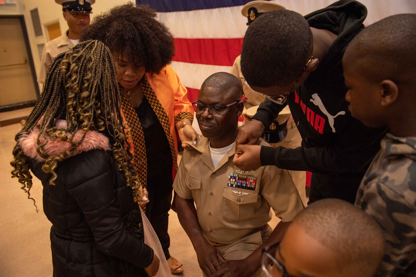 NAVAL STATION NORFOLK (Oct. 21, 2022) Family members pin Chief Logistics Specialist Kokou Moutchou’s anchors during the Naval Surface Force Atlantic chief petty officer pinning ceremony onboard Naval Station Norfolk, Oct. 21, 2022. Nine Sailors received their gold-fouled anchors during the ceremony. (U.S. Navy photo by Mass Communication Specialist 1st Class Jacob Milham)