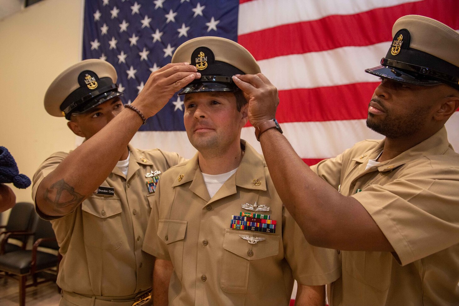 NAVAL STATION NORFOLK (Oct. 21, 2022) Mentors cover Chief Quartermaster Thomas Reeder during the Naval Surface Force Atlantic chief petty officer pinning ceremony onboard Naval Station Norfolk, Oct. 21, 2022. Nine Sailors received their gold-fouled anchors during the ceremony. (U.S. Navy photo by Mass Communication Specialist 1st Class Jacob Milham)