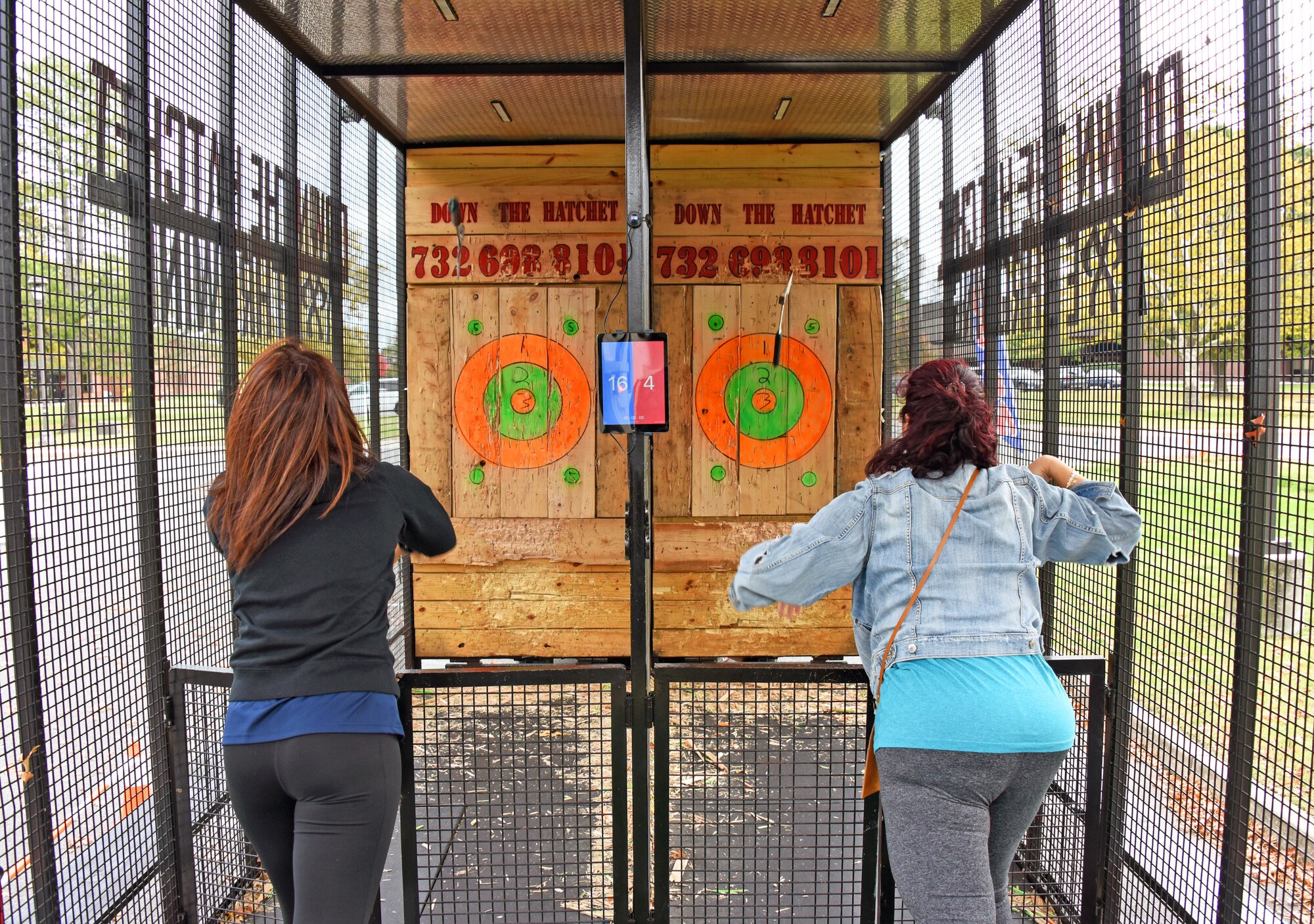 Participants throw hatchets at wooden targets.