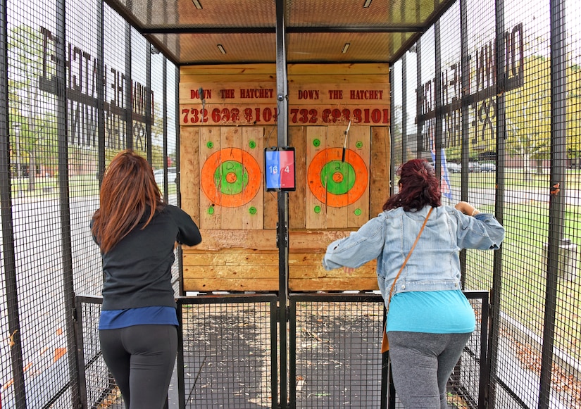 Participants throw hatchets at wooden targets.