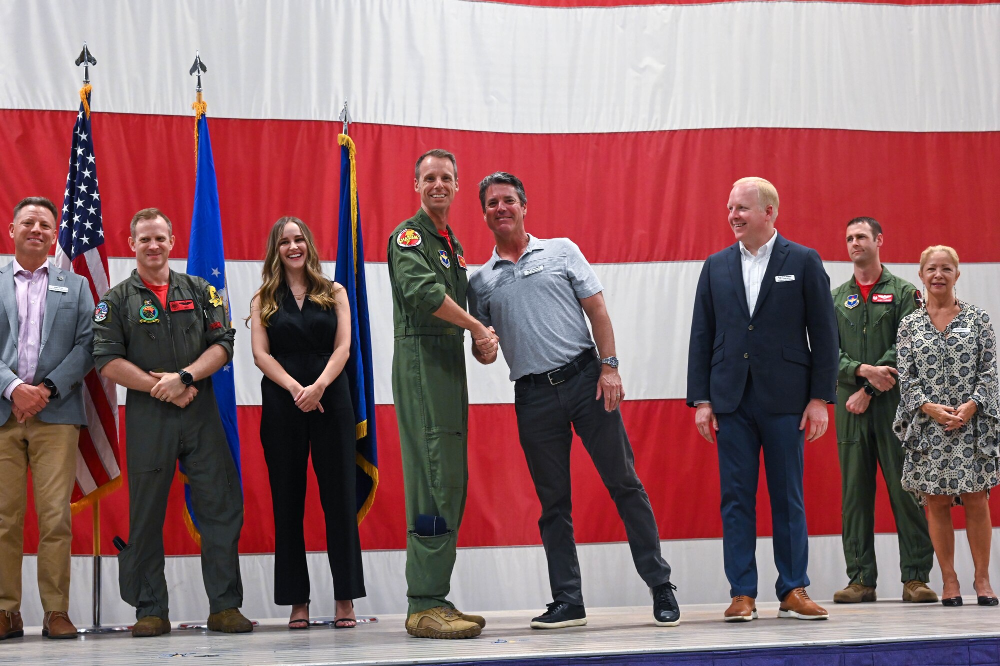 U.S. Air Force Lt. Col. Joshua Larsen, 56th Operation Support Squadron commander, coins Marc Hertzberg and Brandon Klippel, honorary commander inductees, during a ceremony, Oct. 14, 2022, at Luke Air Force Base, Arizona.