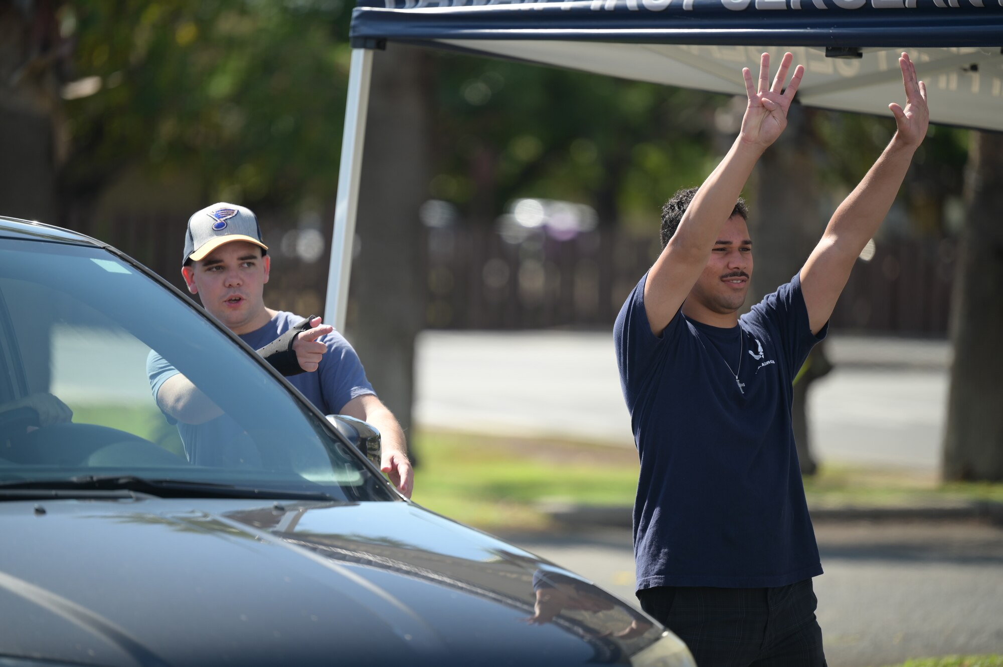 Senior Airman Drue Christian and Airman Antonio Agosto, 613th Air Operations Center air tasking order production technicians, assist military housing residents through a water distribution site on Joint Base Pearl Harbor-Hickam, Hawaii, Oct. 21, 2022. Several volunteers have been working at the Navy and Hickam Exchanges water distribution sites since Oct. 15, 2022, helping military housing residents affected by a water line break on Oct. 14, 2022, gain access to potable water. (U.S. Air Force photo by Staff Sgt. Alan Ricker)