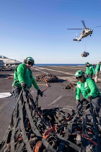 Sailors aboard USS George H.W. Bush (CVN 77) move cargo nets during a vertical replenishment while participating the NATO-led vigilance activity Neptune Strike 22.2.