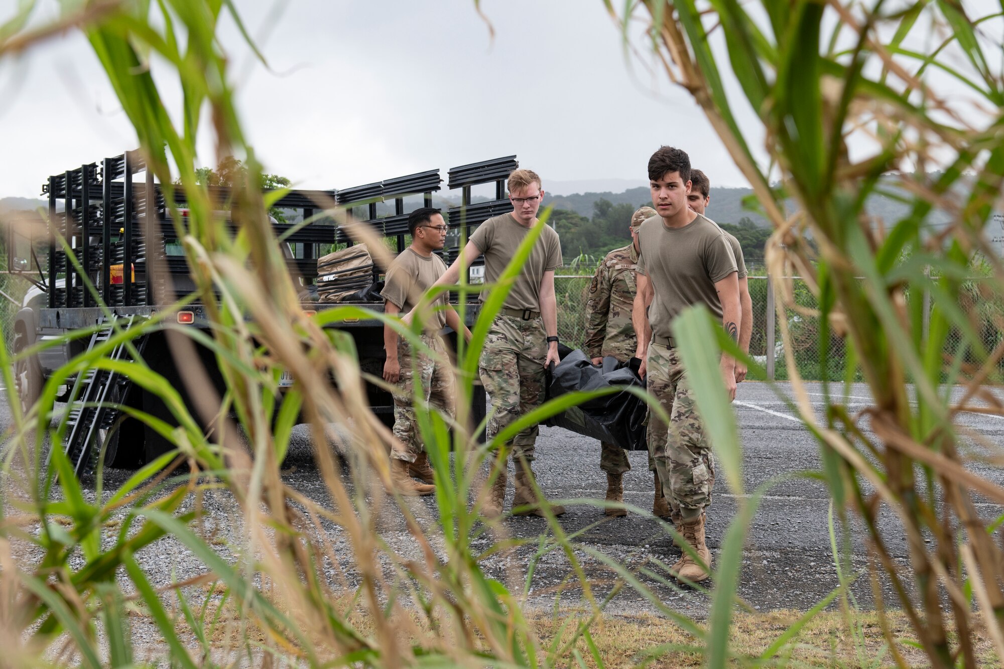 U.S. Air Force Airmen assigned to the 18th Wing unload a tent from the back of a truck during an Agile Combat Employment exercise at Okuma Beach, Japan, Oct. 14, 2022. The 18th Wing is dedicated to developing a force of multi-capable Airmen to drive the mission more effectively through the integration of ACE concepts. (U.S. Air Force photo by Senior Airman Jessi Roth)