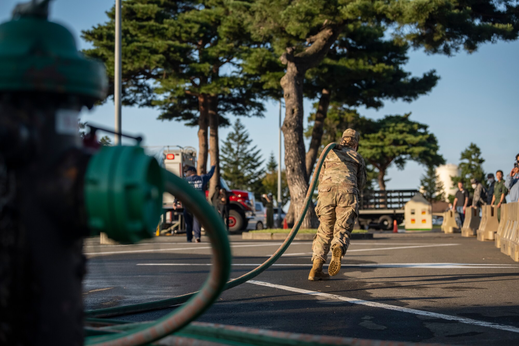 Airman pulling a fire hose during a competition at the annual Fire Muster.