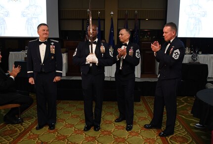 U.S. Air Force Chief Master Sgt. Antonio Cooper, 14th Flying Training Wing command chief, presents a commemorative sword to retired Lt. Gen. Brad Webb, left, while serving as the Sergeant at Arms during the Order of the Sword Ceremony at Keesler Air Force Base, Mississippi, Oct. 15, 2022