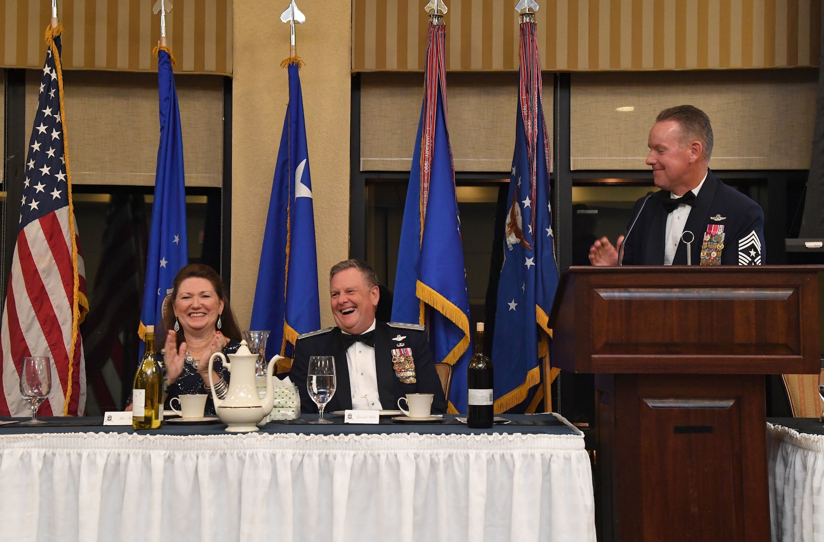U.S. Air Force retired Lt. Gen. Brad Webb and his wife, Dawna, laugh as Chief Master Sgt. Cory Olson, command chief of Air Force Special Operations Command, delivers remarks during the Order of the Sword Ceremony at Keesler Air Force Base, Mississippi, Oct. 15, 2022