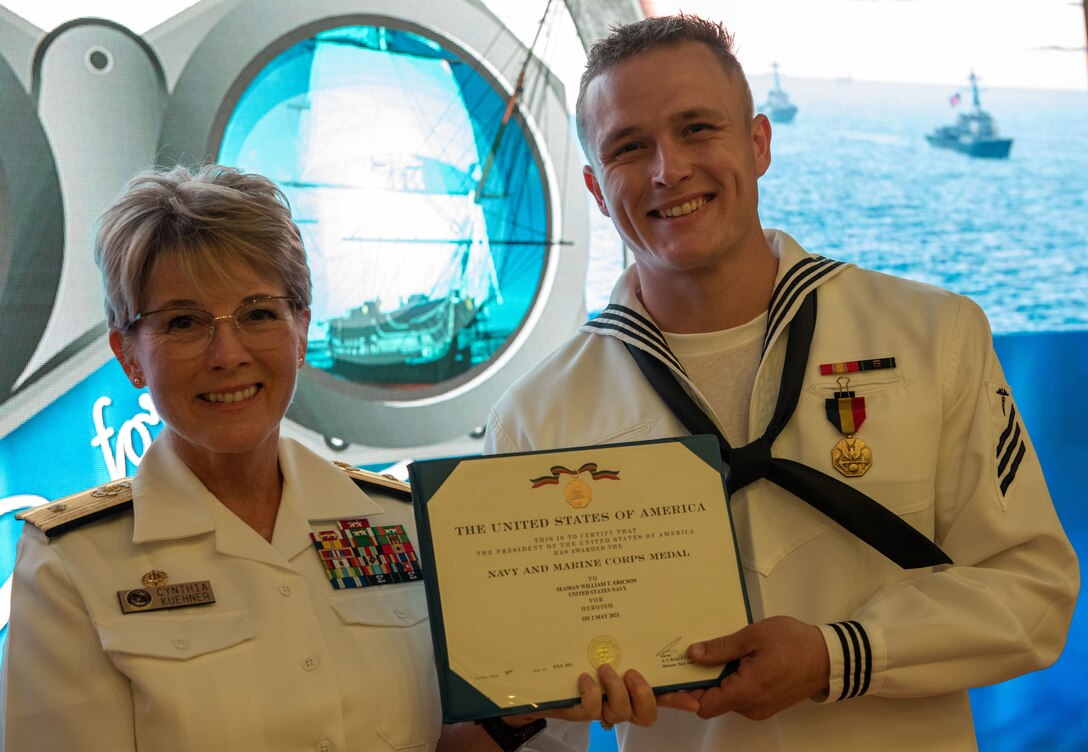 Rear Adm. Cynthia Kuehner, commander of Naval Medical Forces Support Command, presnets Hospital Corpsman William T. Ericson the Navy and Marine Corps Medal in recognition for acts of non-combat heroism during a ceremony recently at the Navy Medicine Training Support Center. While off-duty hiking at the Cabrillo National Monument on May 2, 2021, Ericson observed an adrift vessel with more than 30 distressed passengers near the rocky shoreline. As the vessel was dashed against boulders in six-foot seas, multiple people abandoned the boat in the 60-degree water. (US Navy Photo)