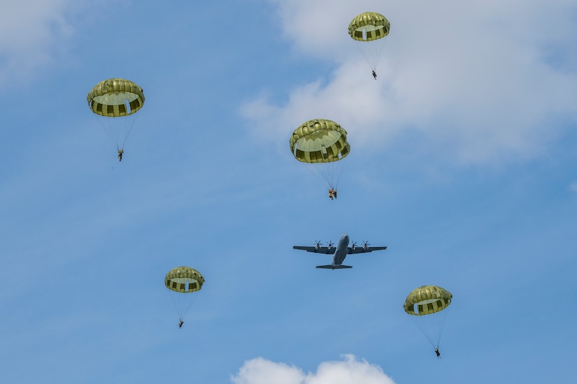 Japanese soldiers descend after jumping from plane.