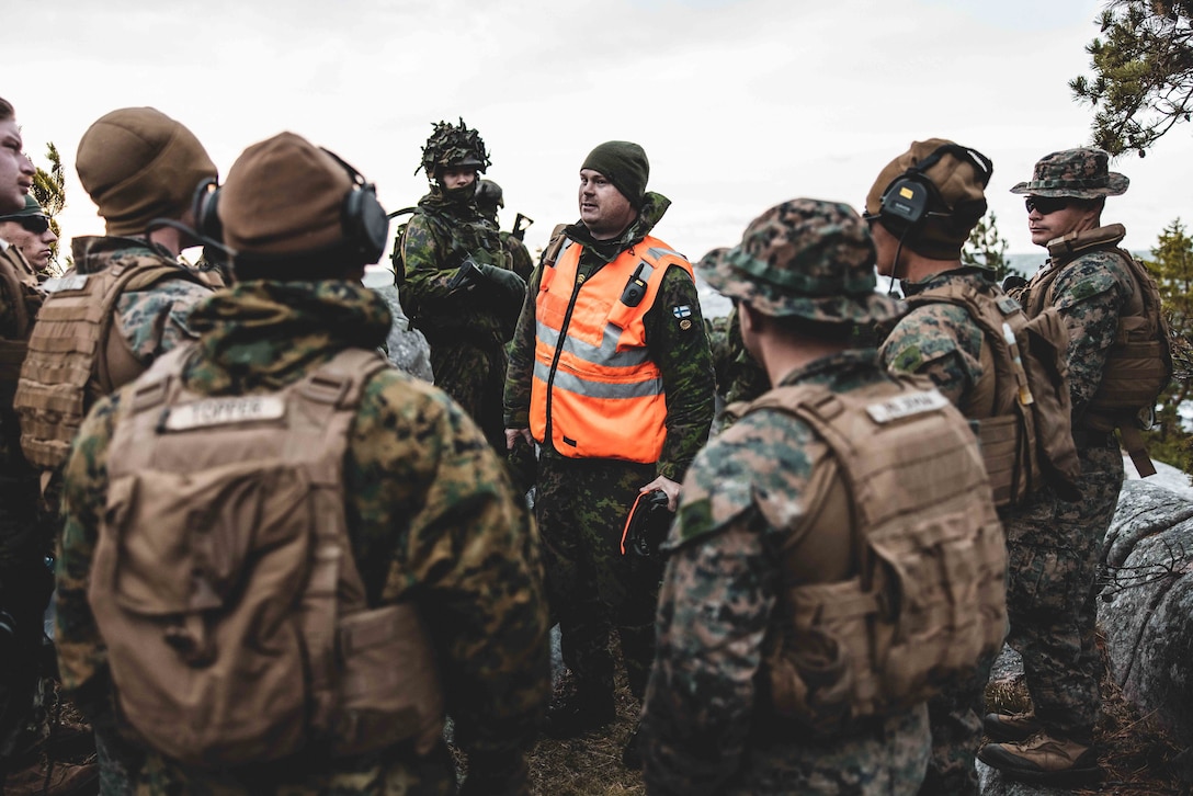Finnish Army Staff Sgt. Benjamin Blomqvist (center), a combat boat craft commander with Vaasa Coastal Battalion, gives a safety brief to Marines before executing a littoral reconnaissance range in preparation for exercise Freezing Winds 22 in Syndalen, Finland, Oct. 8, 2022.
