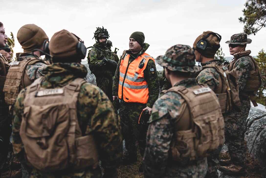 Finnish Army Staff Sgt. Benjamin Blomqvist (center), a combat boat craft commander with Vaasa Coastal Battalion, gives a safety brief to Marines before executing a littoral reconnaissance range in preparation for exercise Freezing Winds 22 in Syndalen, Finland, Oct. 8, 2022.