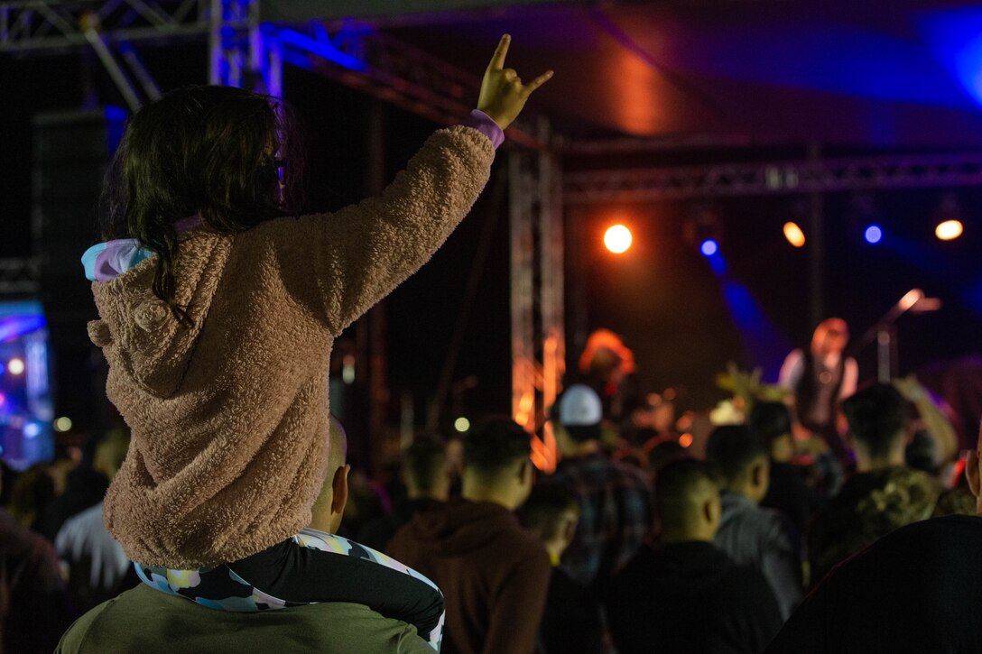 A young metal fan sits on shoulders during a concert at Rocktoberfest, Marine Corps Air Station Cherry Point, North Carolina, Oct. 20, 2022. Marine Corps Community Services Cherry Point hosts Rocktoberfest annually. More than 1,000 service members and civilians gathered to participate in an array of games, listen to live music, and enjoy free food and drinks. (U.S. Marine Corps photo by Lance Cpl. Jade Farrington)