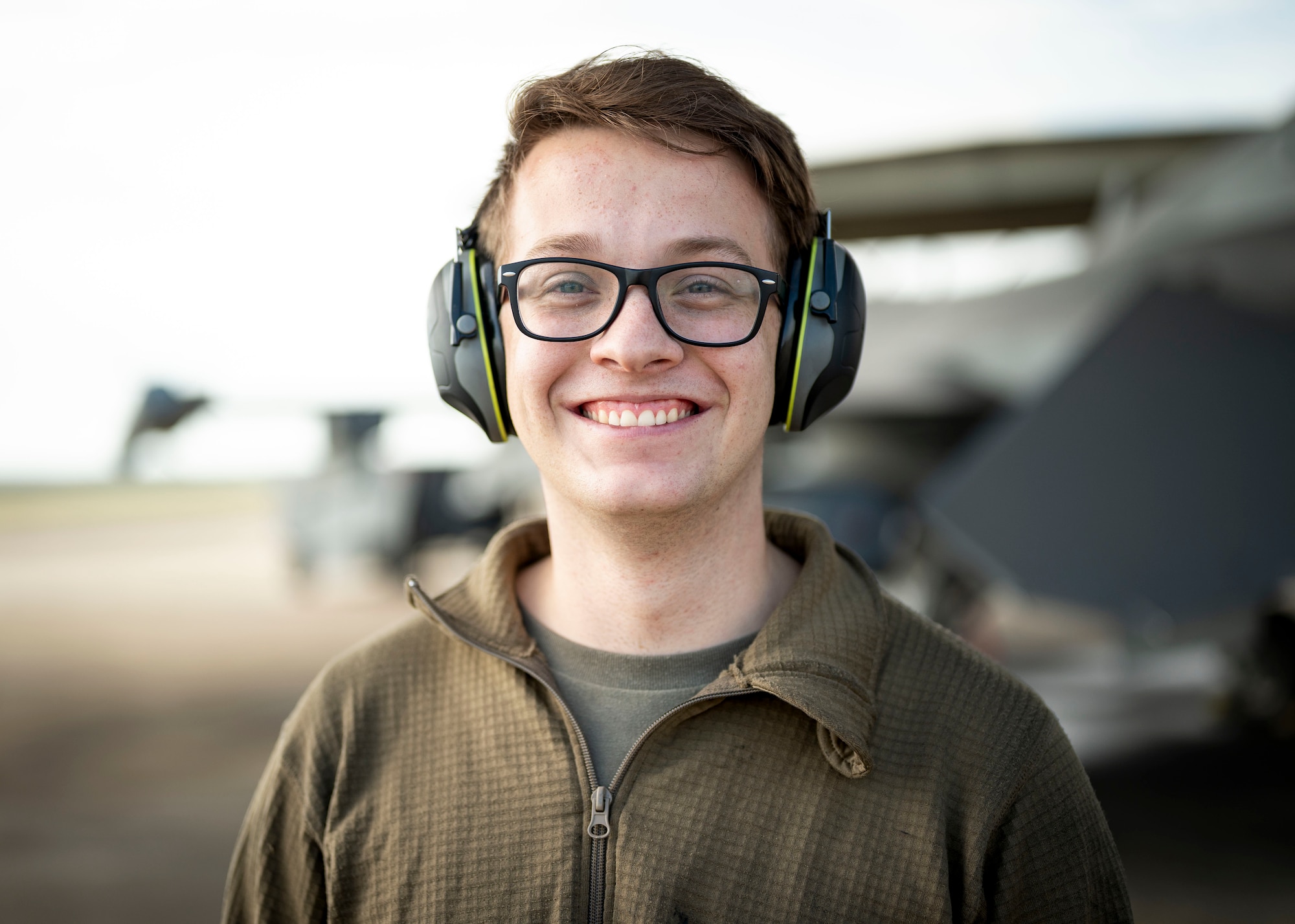 Airman stands in front of a F-16C Fighting Falcon