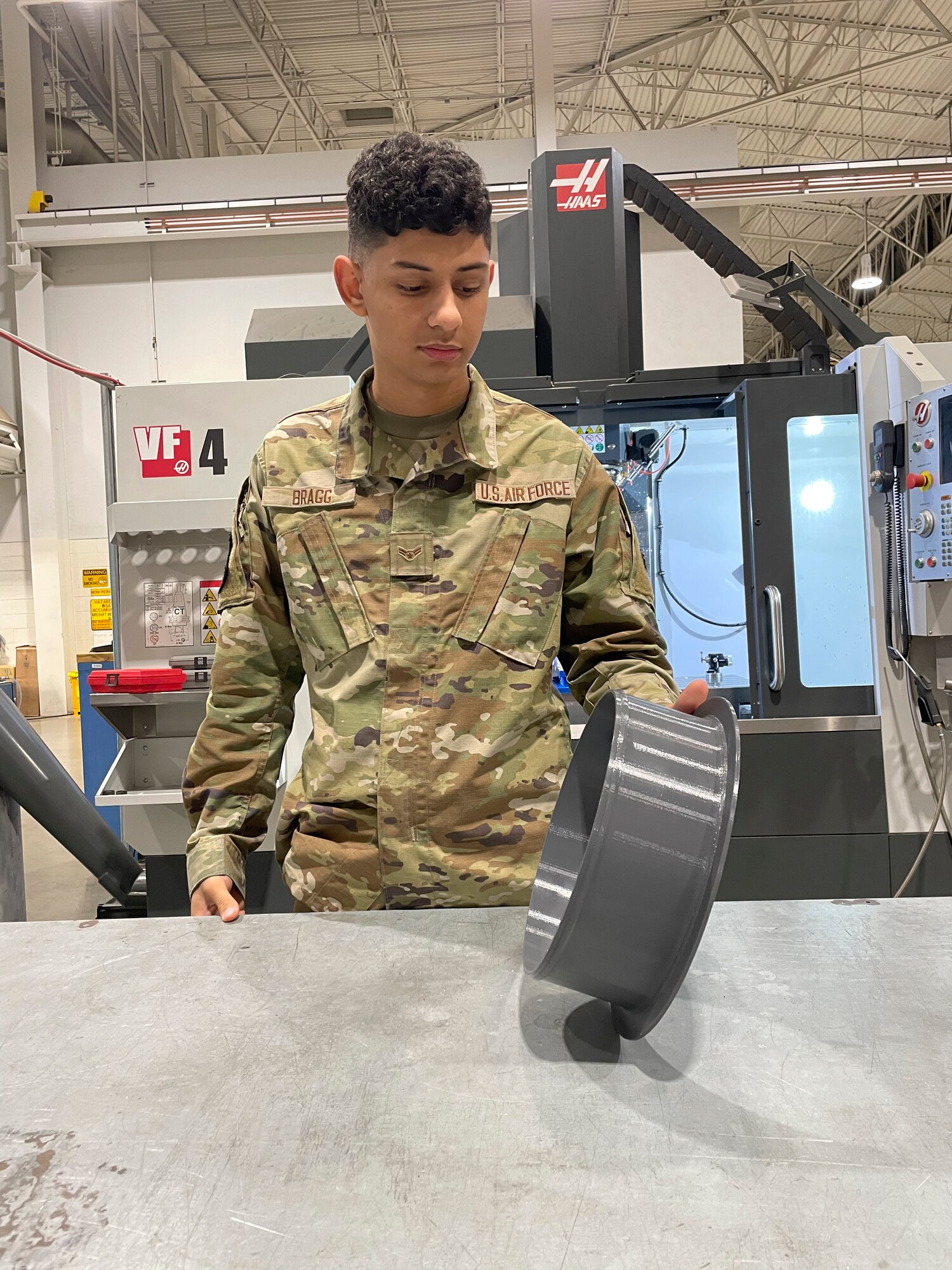 Airman holds a 3d printed aircraft part