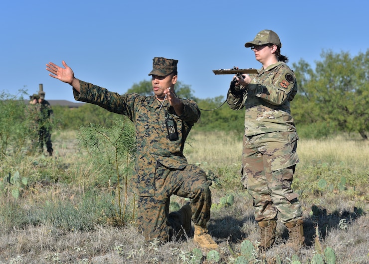 U.S. Marine Sgt. Aaron Nevárez, Marine Corps Detachment Goodfellow Russian course chief, and U.S. Air Force Staff Sgt. Audra Patton, 316th Training Squadron signals intelligence instructor, use a field expedient antenna to determine a window of a signal’s location, Goodfellow Air Force Base, Texas, Oct. 19, 2022. FEAs can be made in the field with cheap and accessible materials to receive specific signals.  (U.S. Air Force photo by Airman 1st Class Zachary Heimbuch)