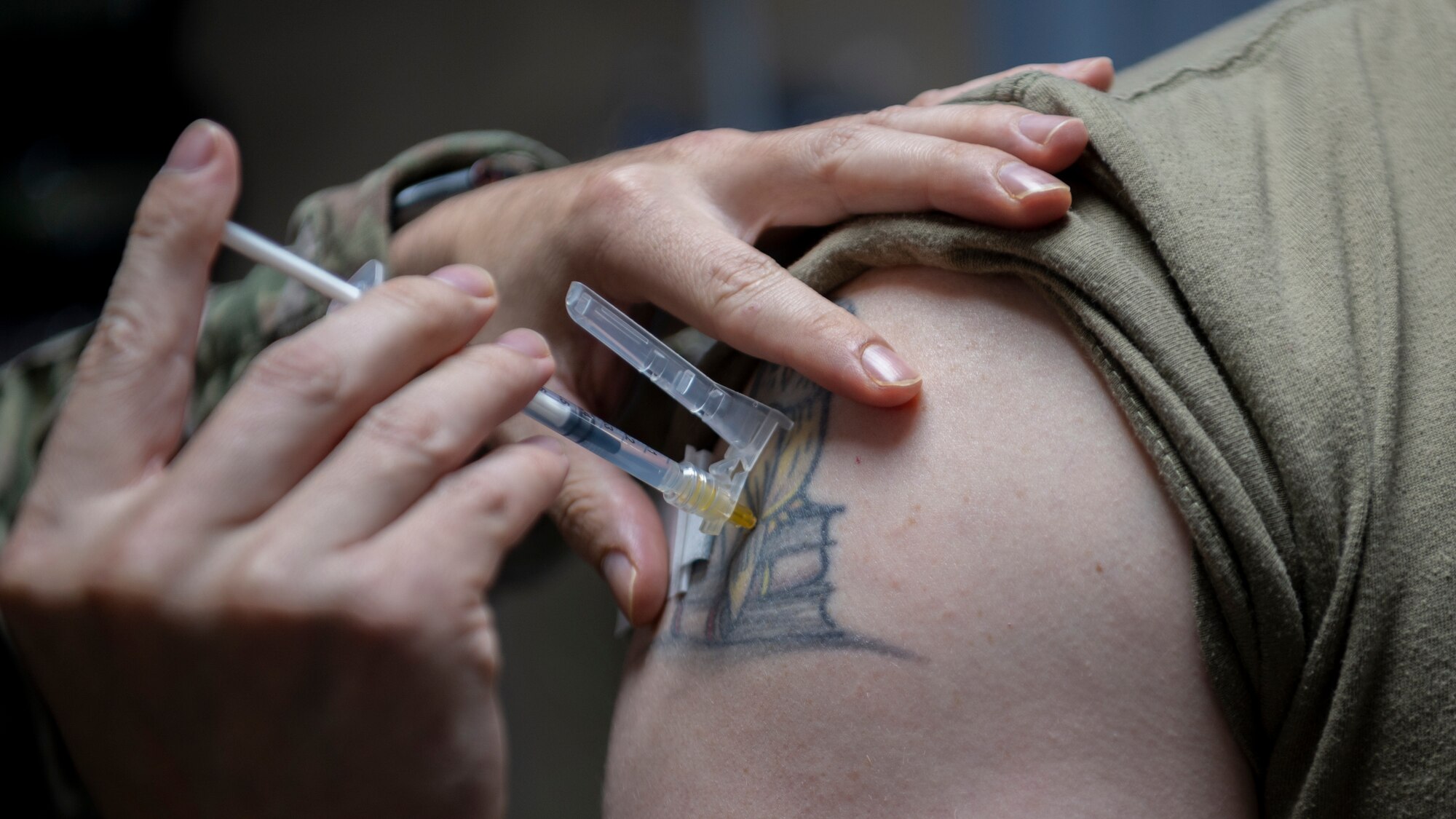 A Medical Technician from the 332d Expeditionary Medical Squadron, injects a COVID-19 booster into a patient at an undisclosed location, Southwest Asia, Oct. 20, 2022. Immunization with the new COVID-19 Booster vaccine provides improved protection against the omicron variants of COVID-19. (U.S. Air Force photo by Tech. Sgt. Jeffery Foster)