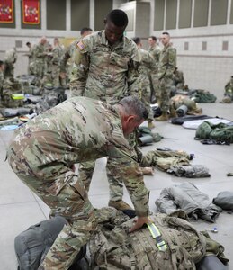 1st Sgt. Reade King from the 300th Military Intelligence Brigade, Utah Army National Guard, helps his fellow competitor, Sgt. Maurice Mannis II from the 204th Maneuver Enhancement Brigade, organizes his gear during the annual Utah National Guard Best Warrior Competition at Camp Williams, Utah, Oct. 16, 2022.