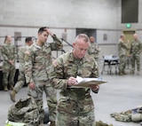 U.S. Army Master Sgt. Michael Baker, an operations noncommissioned officer with the Utah National Guard, inspects the competitor’s gear at the Utah National Guard Best Warrior Competition at Camp Williams, Utah, Oct. 16, 2022.