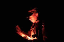 Spc. Logan Phillips, representing the 97th Troop Command, reviews his map during the Utah National Guard Best Warrior Competition at Camp Williams, Utah, Oct. 18, 2022.