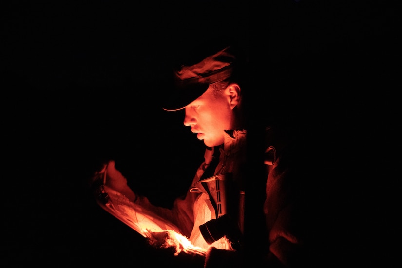 Spc. Logan Phillips, representing the 97th Troop Command, reviews his map during the Utah National Guard Best Warrior Competition at Camp Williams, Utah, Oct. 18, 2022.