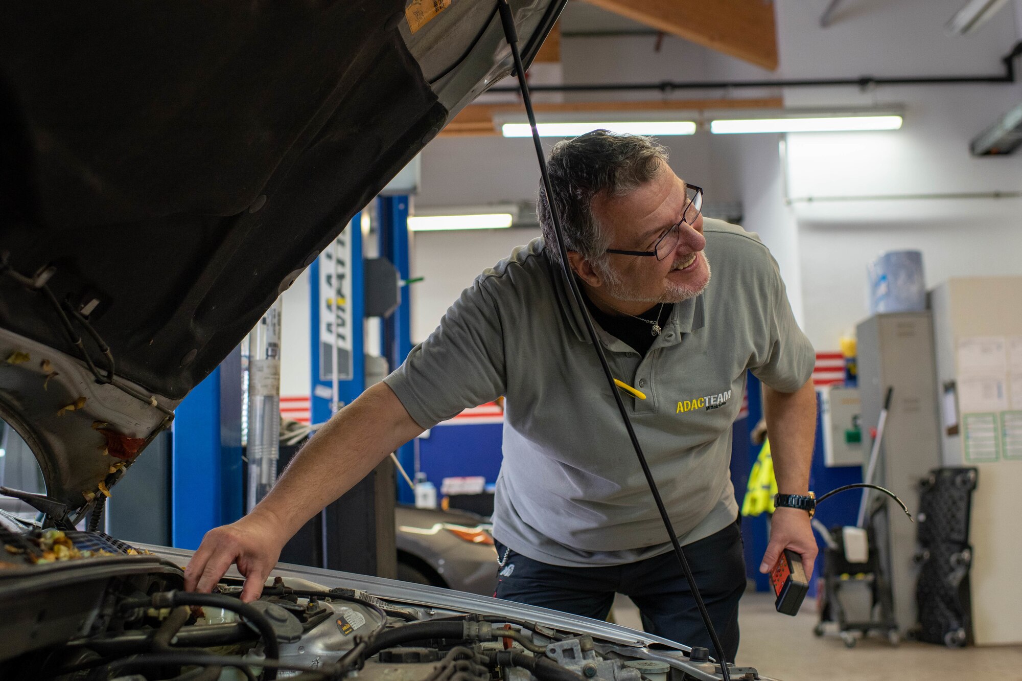 A man checks the brake fluid of a vehicle.