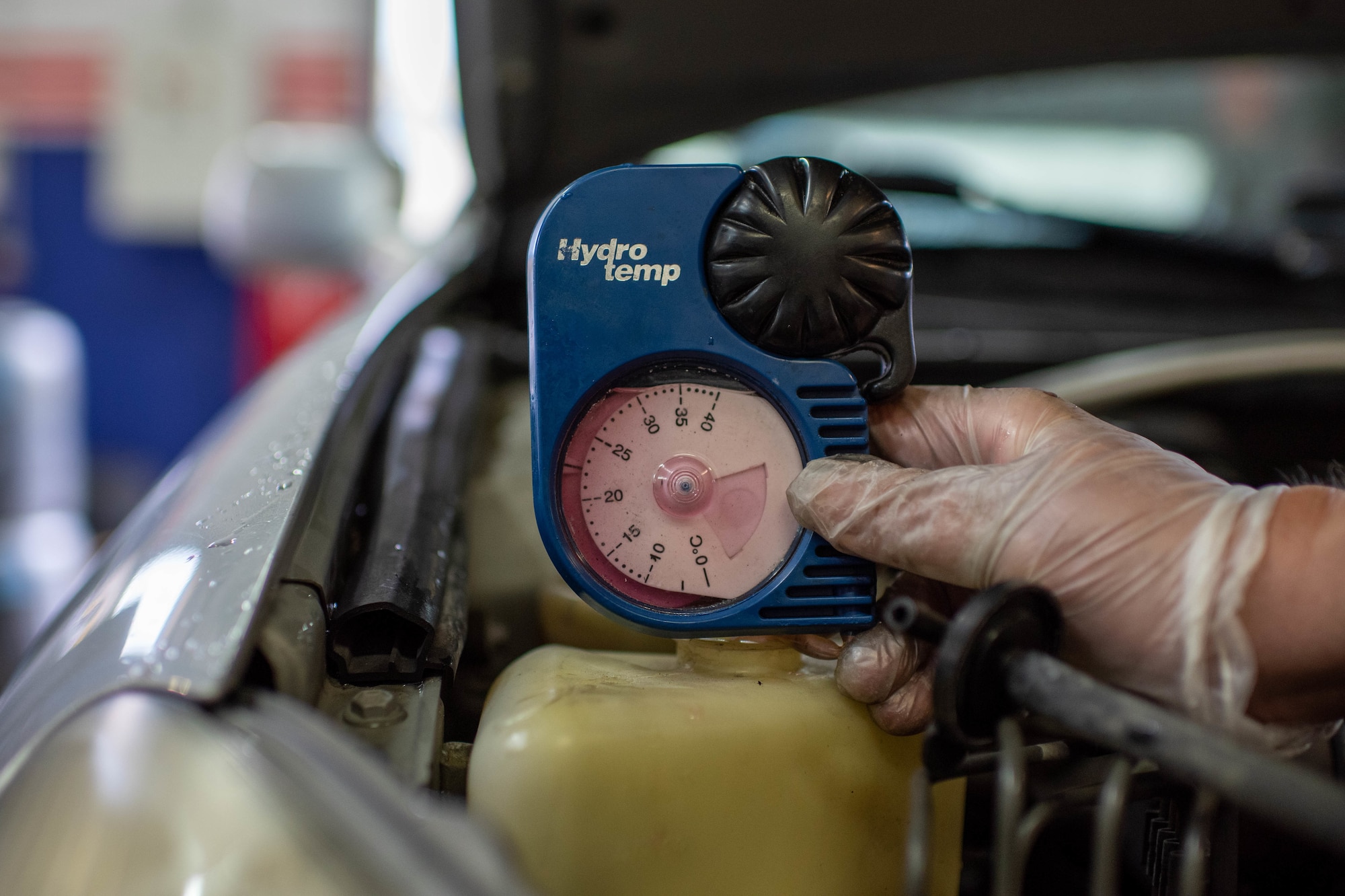 A man checks a vehicle's radiator fluid.