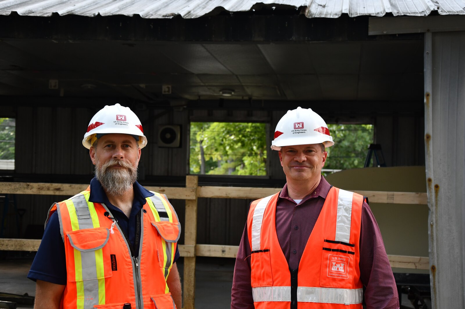 Contracting Officer's Representative Mike Ruppert (left) and Project Manager Silas Bowman (right) stand in front of the Camp Buckner revitalization project at the U.S. Military Academy at West Point, New York.