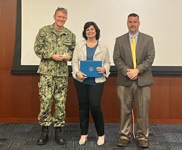 The Arleigh Burke Class (DDG 51) Destroyer Shipbuilding Program Manager Capt. Seth Miller and NAVSEA Program Manager Mr. Michael Dugan present the AEGIS Excellence Award to Toni Checchio, a Naval Surface Warfare Center, Philadelphia Division electrical engineer, for her support during the DDG 51 Flight III (Flt III) development process on Aug. 9, 2022 at Philadelphia. Checchio began working on the Flt III electric plan design concepts in 2011. Her efforts led to the ship’s design being approved in 2015. (U.S. Navy Photo by Jamie Gates/Released)