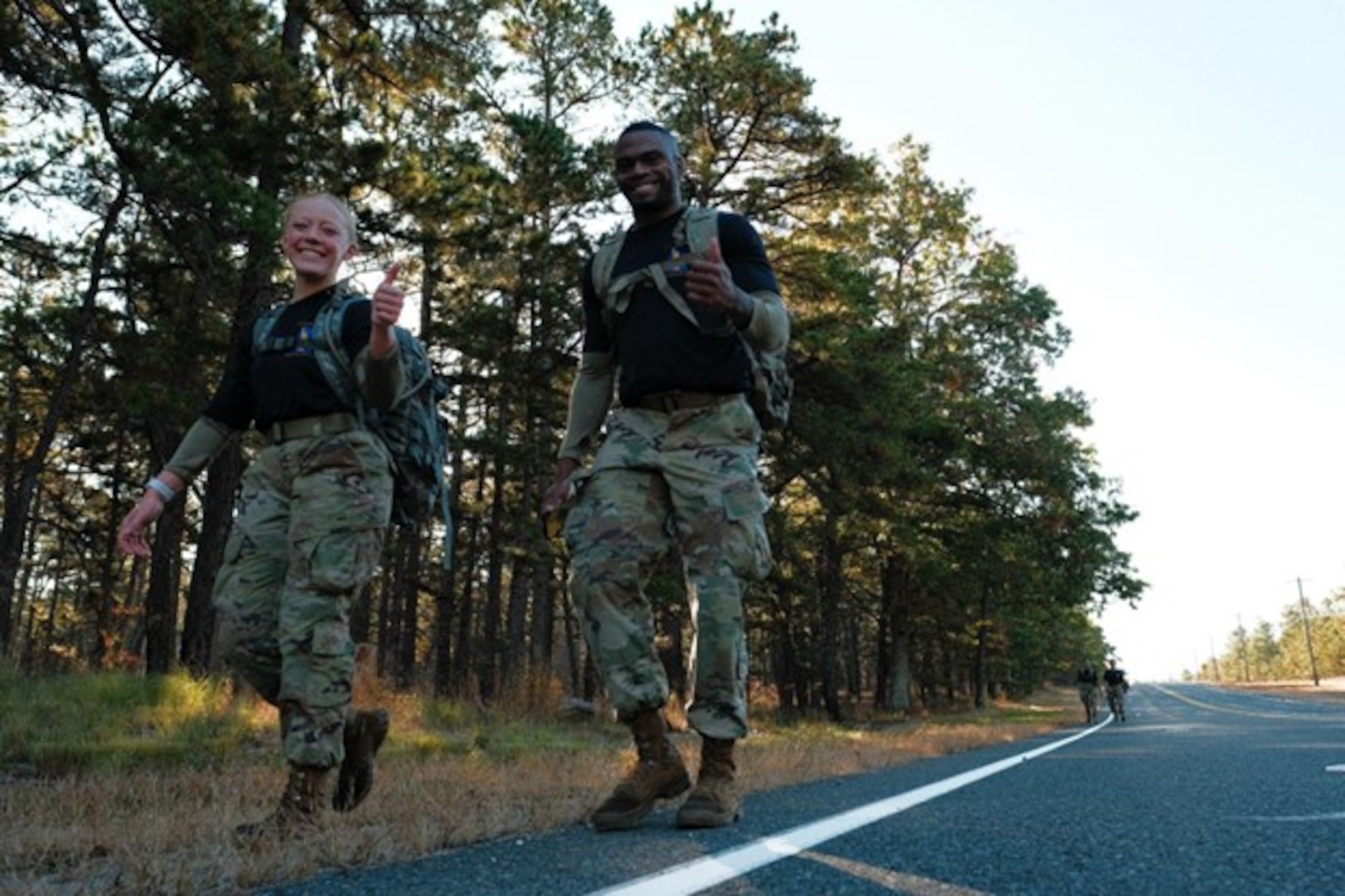 Two soldiers walk along a road
